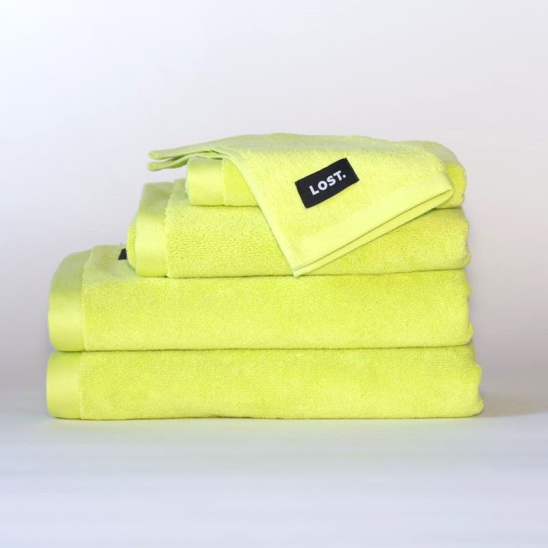 Lost Towel logo on a stack of chartreuse bath towels