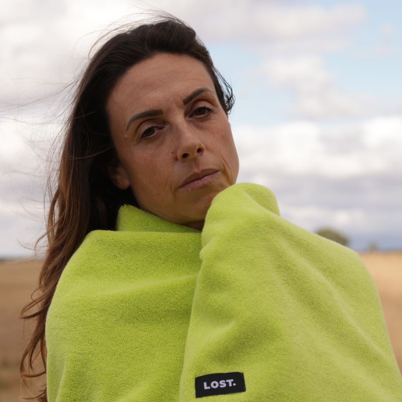 woman with medium brown hair wrapped in a chartreuse bath towel