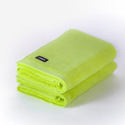 two folded chartreuse bath mats