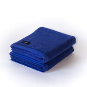 two folded electric blue bath mats