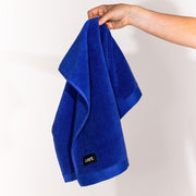 hand holding a draped electric blue hand towel