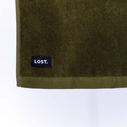 close up of a khaki bath mat showing the lost label