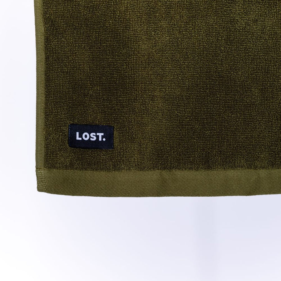 close up of the corner of a khaki face washer with the lost label