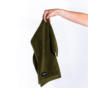 hand holding a draped khaki hand towel