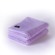 two folded lilac bath mats