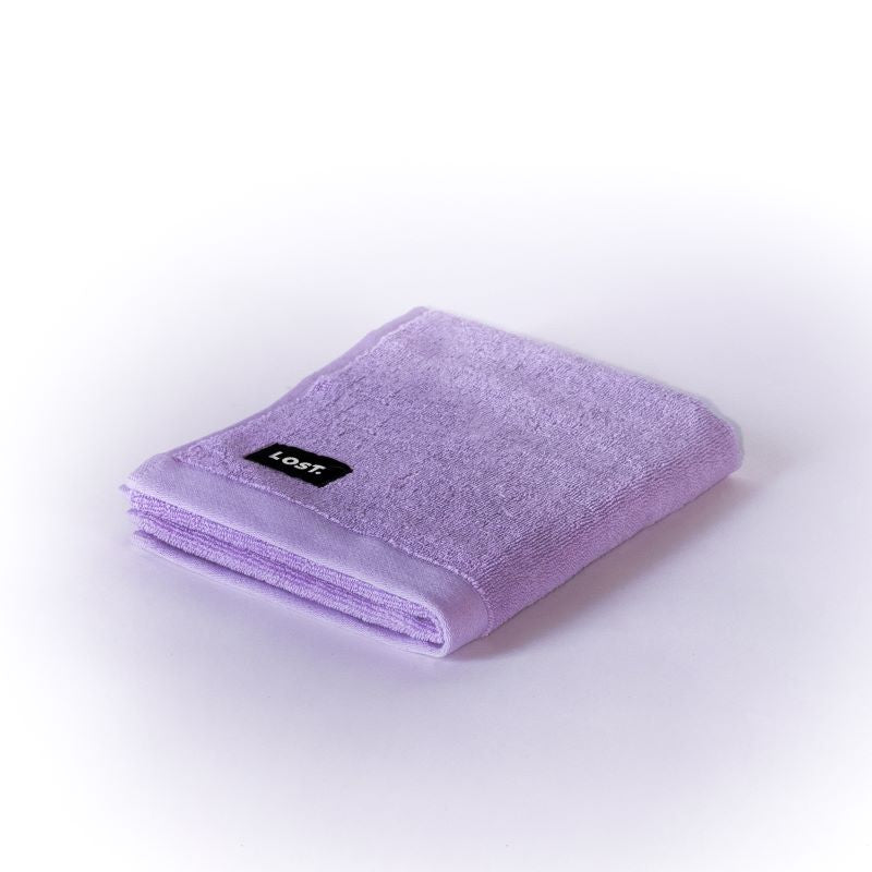 Lost Towels logo on a lilac hand towel