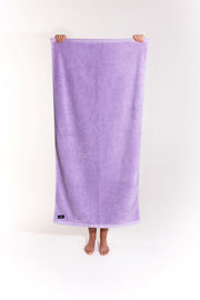 Lilac towel held by person with hands and feet showing