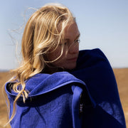 woman with long blonde hair wrapped in an electric blue towel