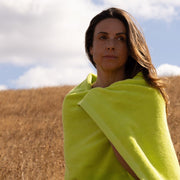 Woman with medium brown hair wrapped in chartreuse bath towel