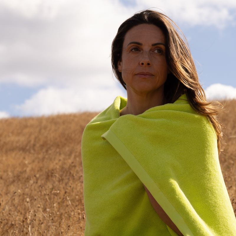 Woman with medium brown hair wrapped in chartreuse bath towel