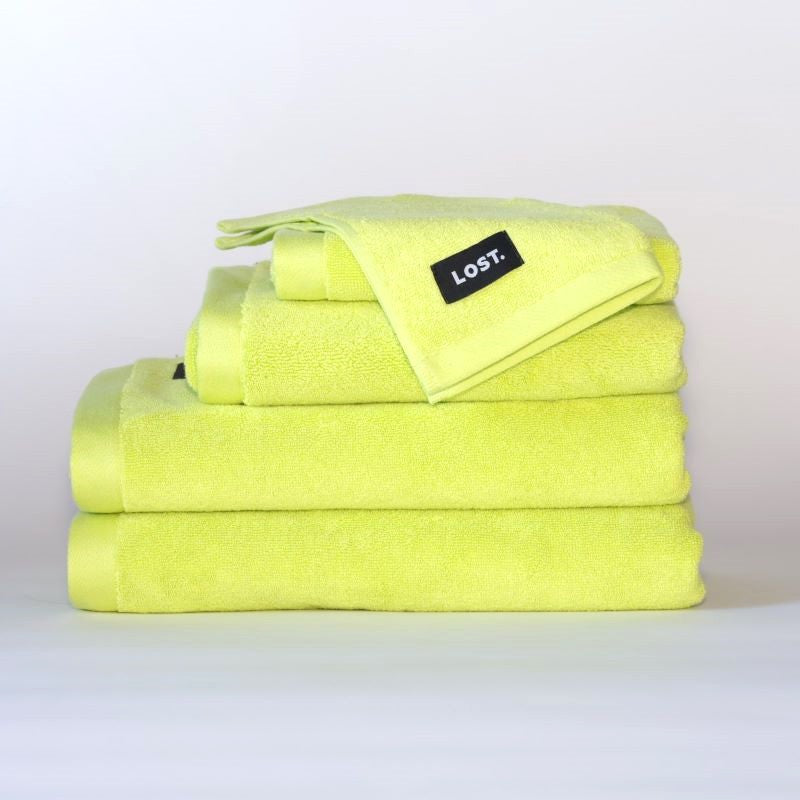 Lost Towels logo on a stack of chartreuse bath towels