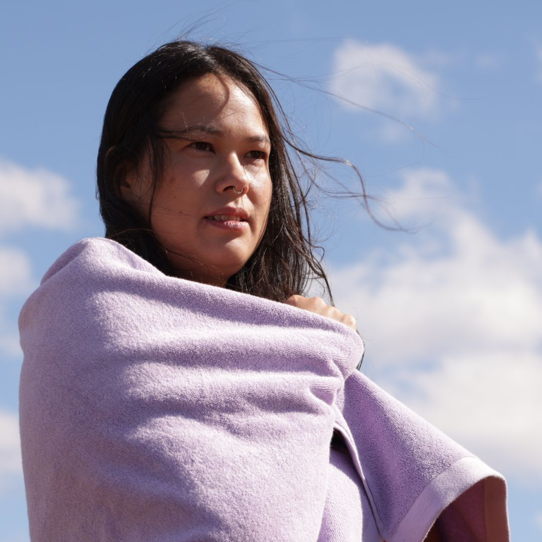 woman with dark brown hair wrapped in lilac towel